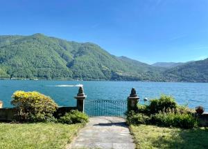 a path next to a body of water with mountains at Lakeside Paradise Porlezza in Cima