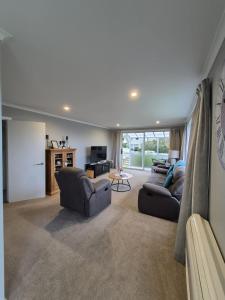 ein Wohnzimmer mit zwei Sofas und einer Küche in der Unterkunft Unit 46a in Timaru