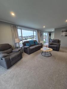 ein großes Wohnzimmer mit Sofas und einem Tisch in der Unterkunft Unit 46a in Timaru + 5 Fotos