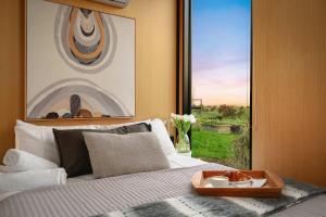 a bedroom with a bed with a tray of food on it at Belrose Estate by Tiny Away in Dumbalk
