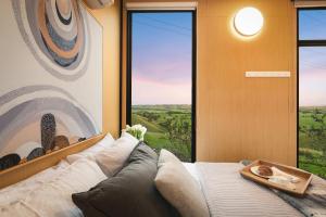 a living room with a couch and a large window at Belrose Estate by Tiny Away in Dumbalk