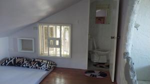 a white room with a bed and a window at Beachfront AC Cave Cabin for 10pax in Caba