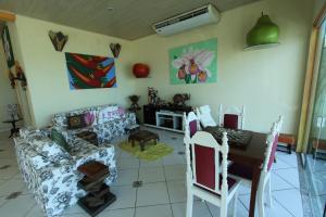 a living room with a couch and a table at Pousada Casa de Pedra in Boicucanga