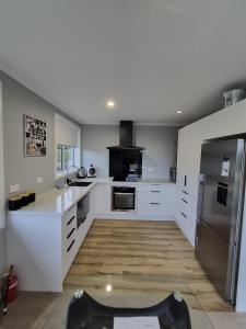 eine Küche mit weißen Schränken und einem Edelstahlkühlschrank in der Unterkunft Unit 46a in Timaru