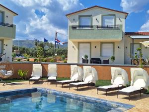 a group of chairs sitting next to a swimming pool at Resort Finikas in Alexandroupoli