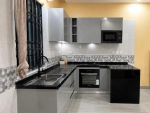 a kitchen with a sink and a stove at Rosebank Villas in Luanda