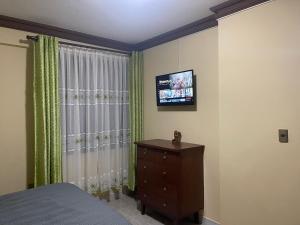 a bedroom with a bed and a television on a wall at Casa Danna in Sucre