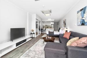 a living room with a couch and a tv at 188 Apartments in Perth