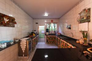 a kitchen with a counter and a sink in it at Pousada Casa de Pedra in Boicucanga