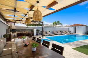an outdoor patio with a pool and a table and chairs at Pervolia House Private Pool Near Airport in Kremasti +27 photos