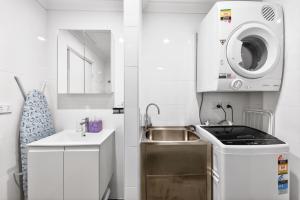 a small kitchen with a sink and a washing machine at 188 Apartments in Perth +35 photos