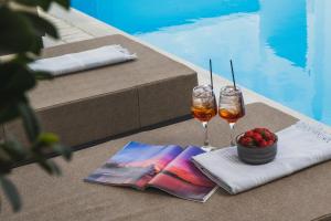 a table with two glasses of wine and a bowl of fruit at Pervolia House Private Pool Near Airport in Kremasti