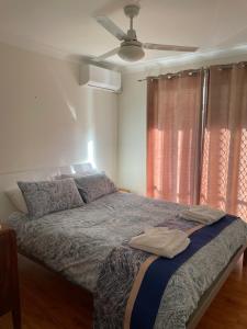 a bedroom with a bed with a ceiling fan at Salt and Sea-renity in Russell Island