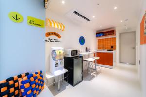 a kitchen with a refrigerator and a counter with stools at Hotel LETS POP in Seoul