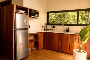 a kitchen with a stainless steel refrigerator and a window at Nuakú Jungle in Aguas Zarcas +32 photos