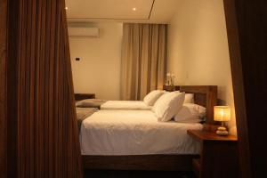 a bedroom with a bed with white sheets and a window at Nuakú Jungle in Aguas Zarcas
