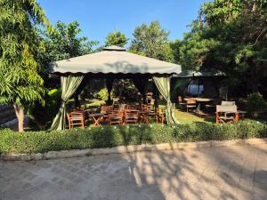 a gazebo with tables and chairs in a garden at Teresita Home JKIA in Nairobi