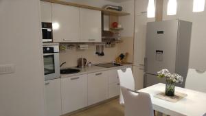 a white kitchen with a table and a refrigerator at Penthouse Znjan in Split