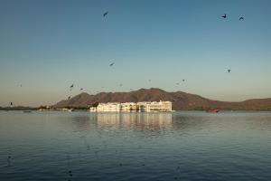 a large building in the middle of a large body of water at Minimalist - Lake Pichola Edit in Udaipur