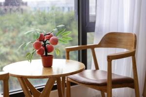 a table with a potted plant on it next to two chairs at Thai Thinh Hotel Grand World in Phú Quốc