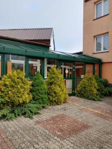 a building with bushes in front of a building at Orwsnoch in Mielno