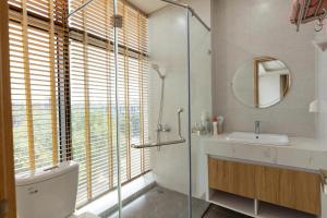 a bathroom with a shower and a toilet and a sink at Thai Thinh Hotel Grand World in Phú Quốc +21 photos