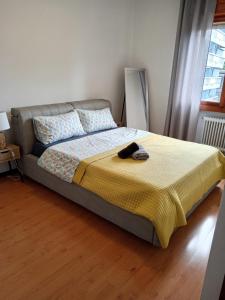 a bedroom with a bed with a yellow blanket at Appartamento Malignani in Cervignano del Friuli