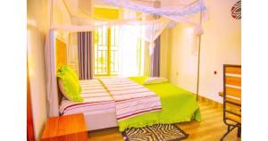 a bedroom with a canopy bed with a window at Breeze House Hotel in Kigali