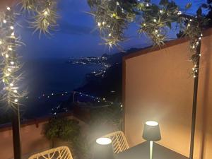 a balcony with a view of the ocean at night at L' agAve in Forza dʼAgro