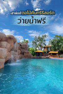 a waterfall in a pool at a resort at ตอไม้คันทรีรีสอร์ท in Ban Maklua Mai
