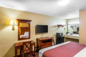 a hotel room with a bed and a flat screen tv at Rodeway Inn Goodlettsville South in Goodlettsville