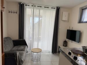 a living room with a couch and a large window at Résidence Villa Landes in Gien