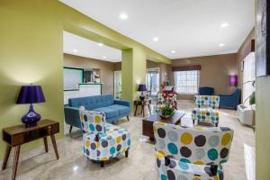 a living room with a blue couch and chairs at Quality Inn Cadiz in Cadiz