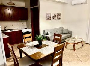 a kitchen and living room with a table and a couch at Katies cozy corner in Chios