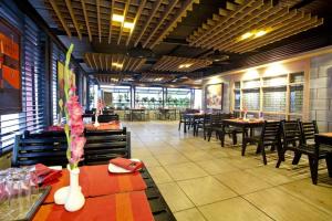 a dining room with tables and chairs in a restaurant at Well Park Residence in Chittagong +59 photos