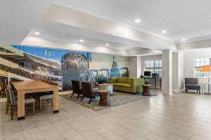 a lobby with a large painting of a dog on the wall at Clarion Pointe Starkville near University in Starkville