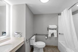 a white bathroom with a toilet and a sink at Clarion Pointe Starkville near University in Starkville +33 photos