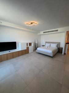 a bedroom with a bed and a flat screen tv at sea&sky luxury suite מילה דירות אירוח in Eilat
