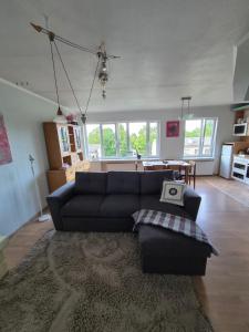 a living room with a blue couch and a table at Vintažys studeja in Rēzekne