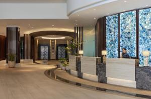 a lobby of a hotel with a woman looking out the window at Dusit Thani Mactan Cebu Resort in Mactan