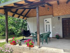 a patio with a table and chairs and a swing at Studio Lejla in Kula