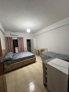 a hotel room with two beds and a table at Ajsi Apartments in Durrës