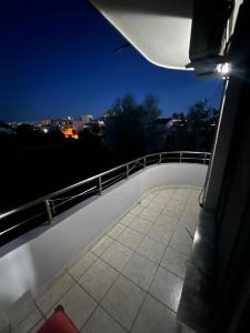 a balcony with a view of a city at night at Ajsi Apartments in Durrës