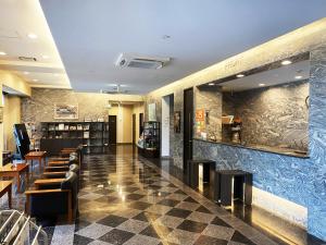 a restaurant with a lobby with chairs and a bar at Hotel Route-Inn Mojiko in Kitakyushu