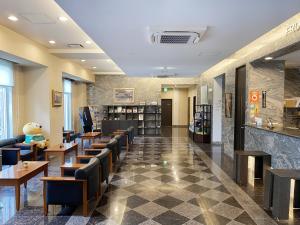 a restaurant with tables and chairs in a lobby at Hotel Route-Inn Mojiko in Kitakyushu