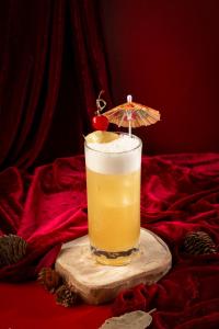 a drink on a cutting board with an umbrella at Bud Brew Beyond Dispensary and Hotel in Bangkok
