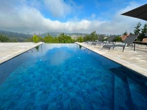 a swimming pool with chairs and blue water at Casa del mir in Dayr al Qamar