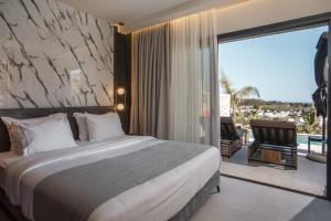 a hotel room with a bed and a large window at Celeste Luxury Villas in Lartos +95 photos
