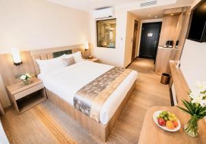 a hotel room with a bed and a table with a bowl of fruit at Flower Hotel Ulaanbaatar in Ulaanbaatar