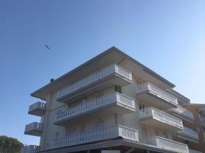 un edificio con balcones en un lateral en Appartamenti al Cigno, en Lignano Sabbiadoro